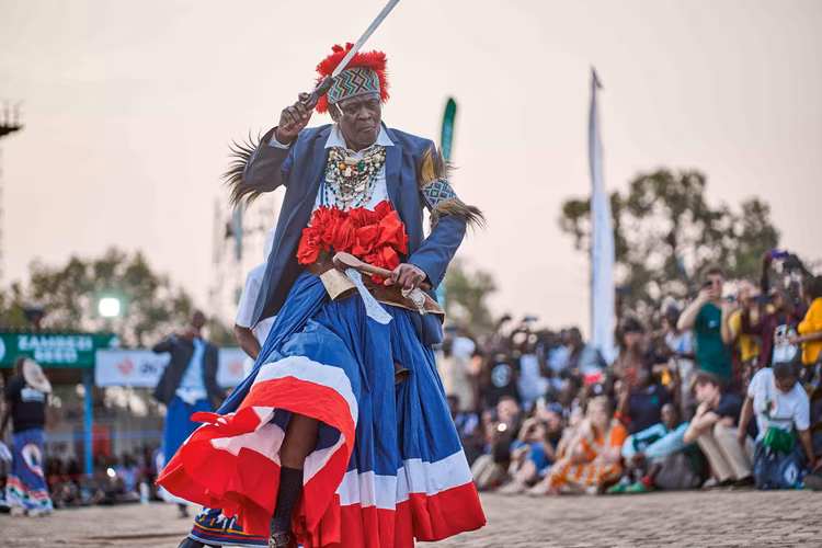 The Mwata raises the mpoko, and mbafi cuts the air, then points skyward and earthward, signalling divine mandate and grounded authority. (Image by Chona Mweemba for Nkwazi Magazine).