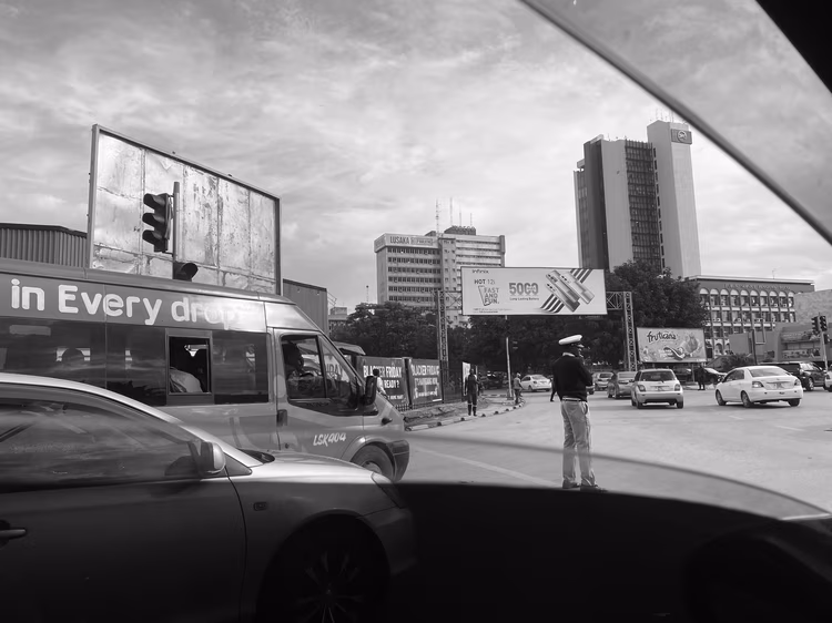 As traffic builds across Lusaka, buses become front-row seats to the city's energy, from roadside vendors to the ever-changing streetscape. (Image by Eddie Musabula).