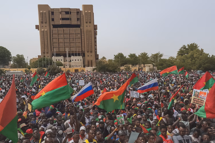Supporters wave Russian and Burkina Faso flags at a rally in support of Traore. (Image is artists impression).