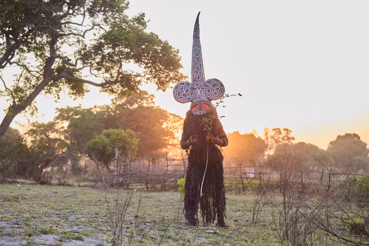 An initial glimpse of these dancers may be frightening, but it’s important to understand that these are representations of the spirit world of warriors assigned to protect their people. (Image by Justin Kunda for Nkwazi Magazine).