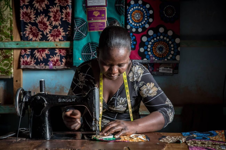 African tailor working with chitenge fabric (SOPA Images/Alamy).